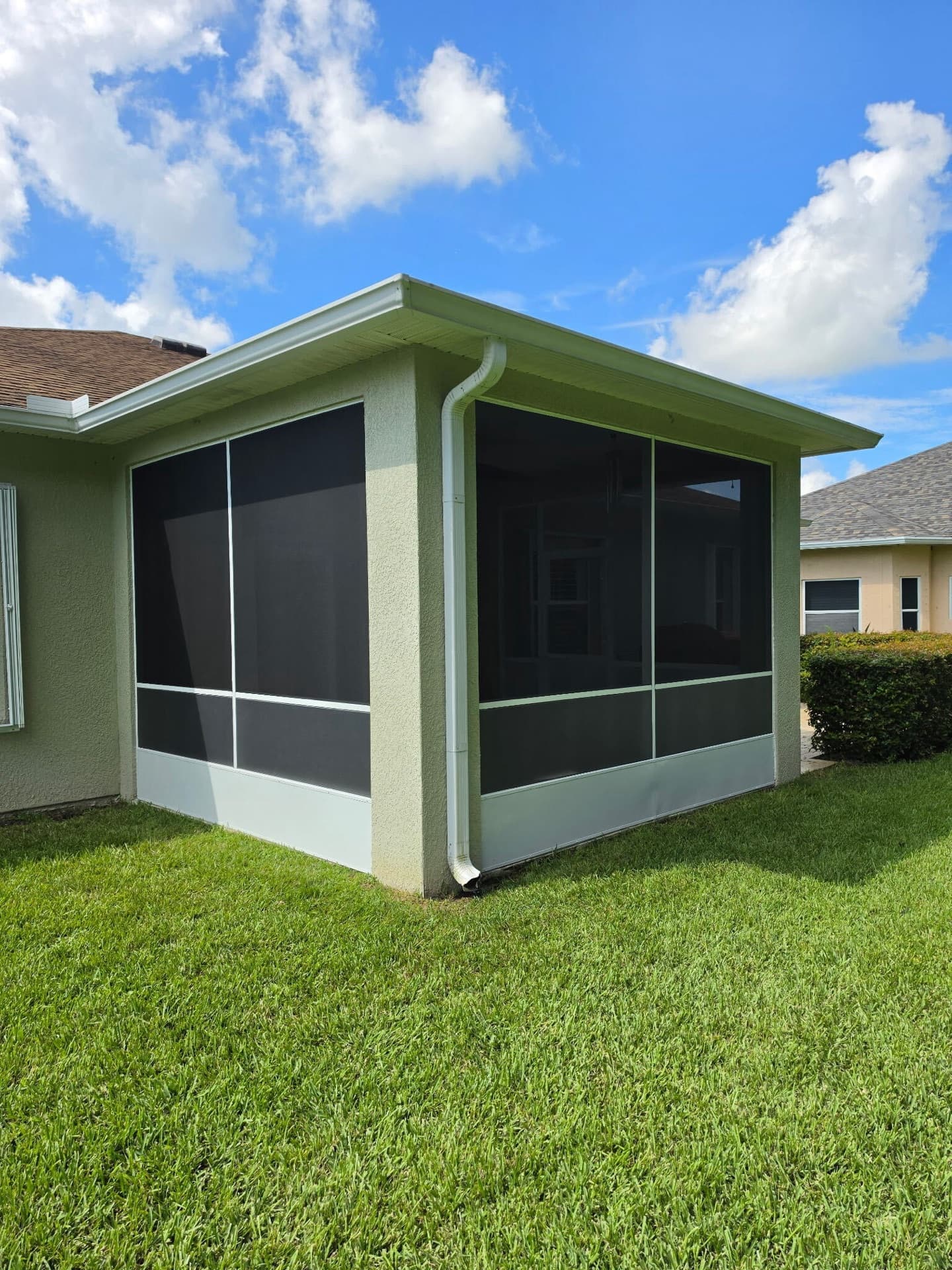 Covered patio corner enclosed with white-framed screen walls on a Florida home
