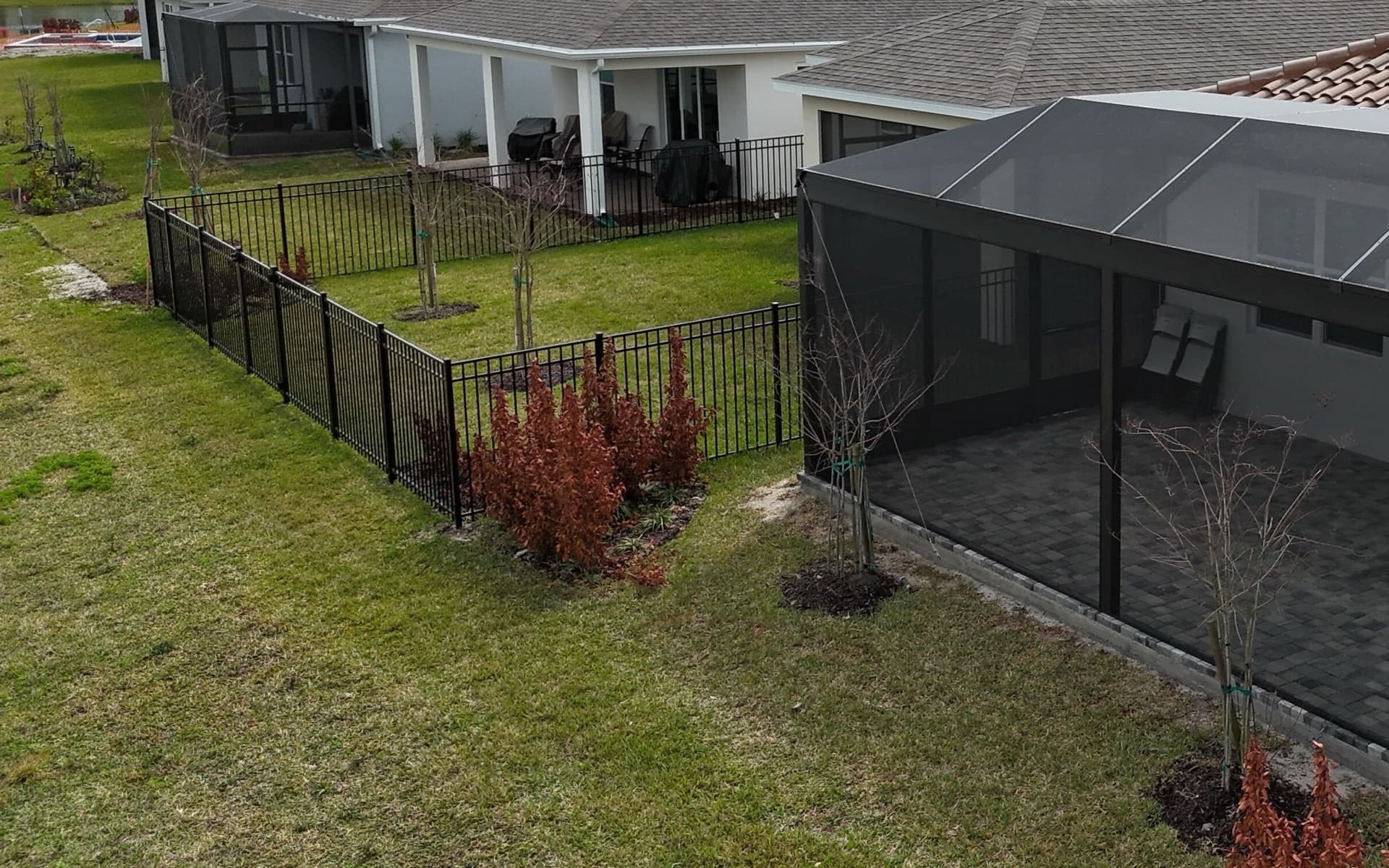 Black aluminum picket fence around the backyard of a Brevard County home