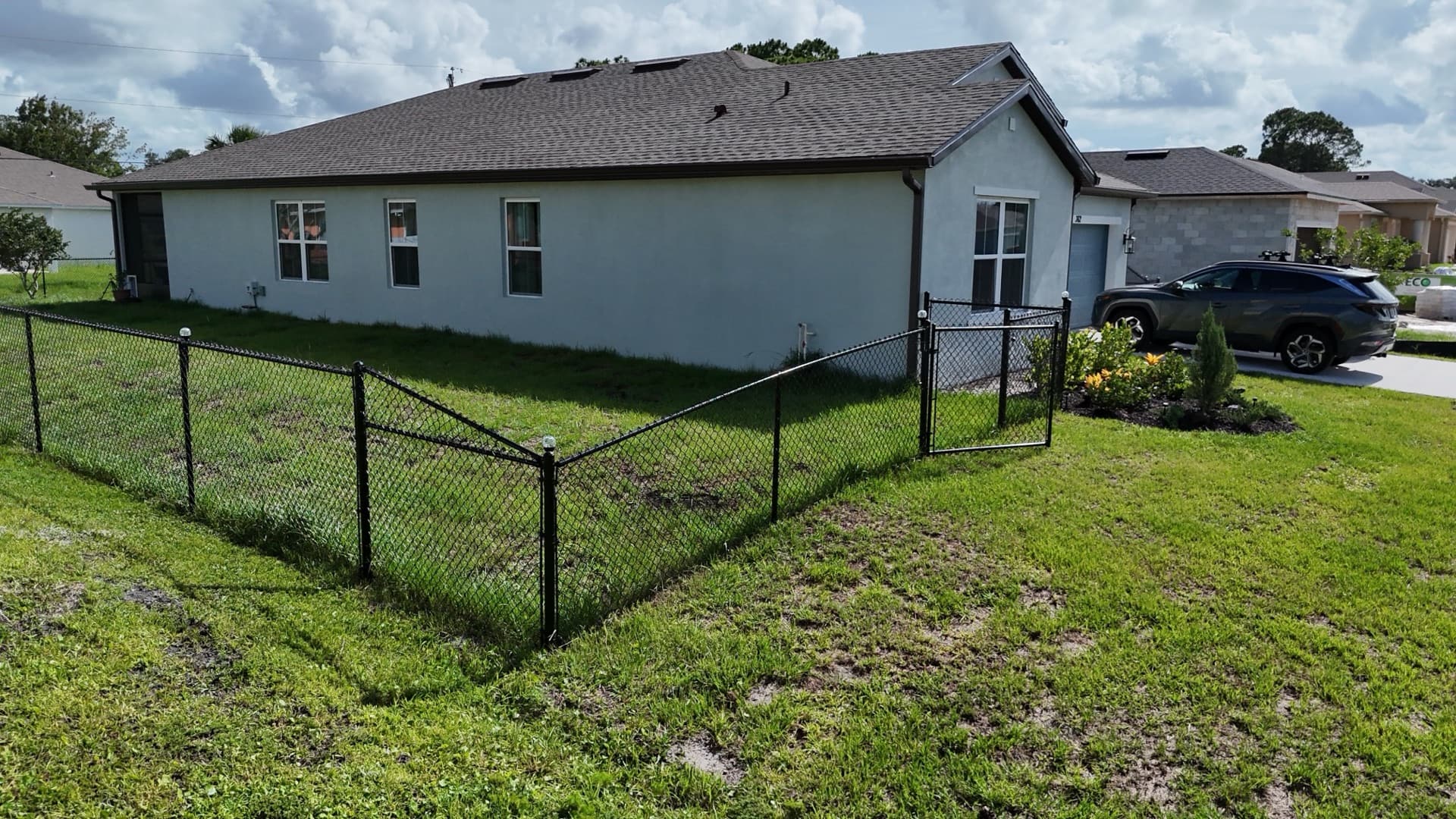 Black chain link fence enclosing the side yard of a Florida home