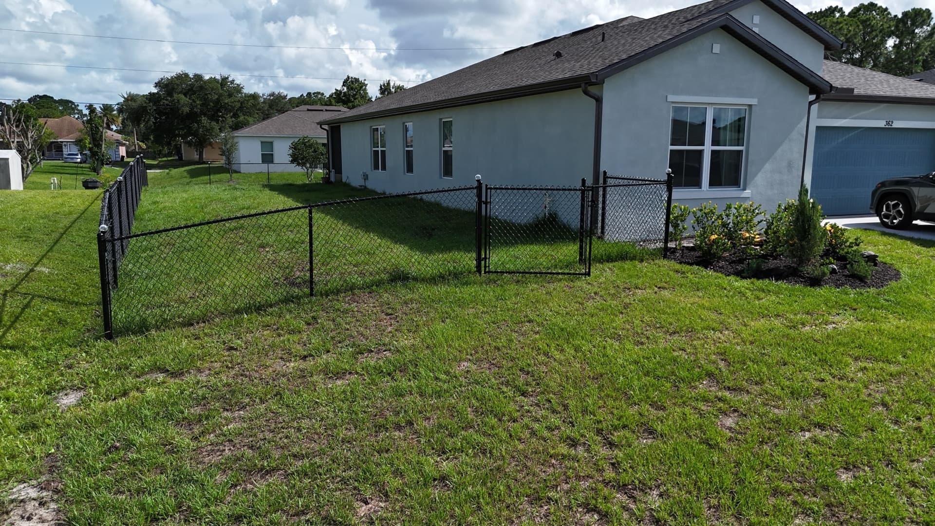 Black chain link fence with gates installed around a Brevard County backyard