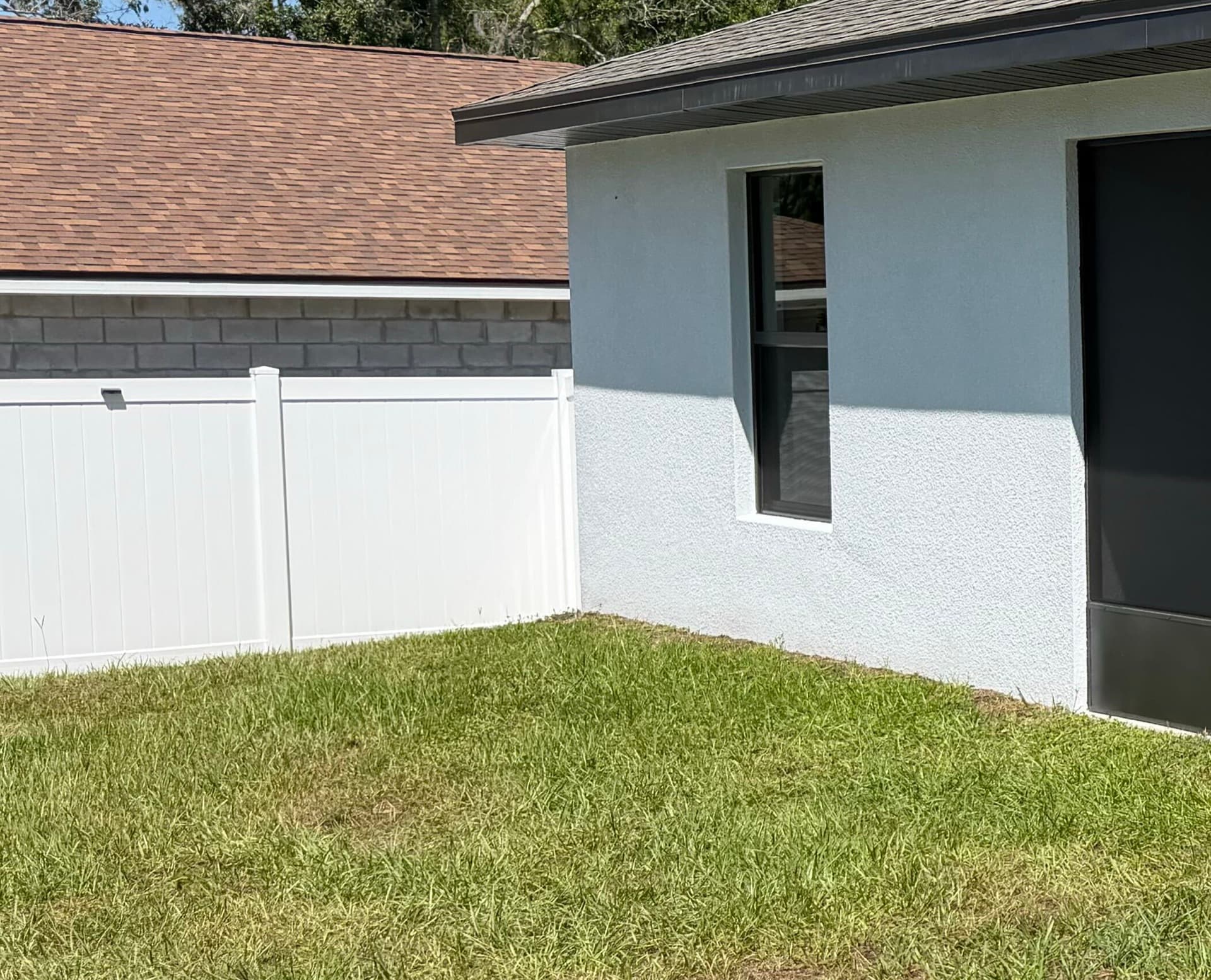 White 6 foot vinyl privacy fence installed along a Brevard County backyard