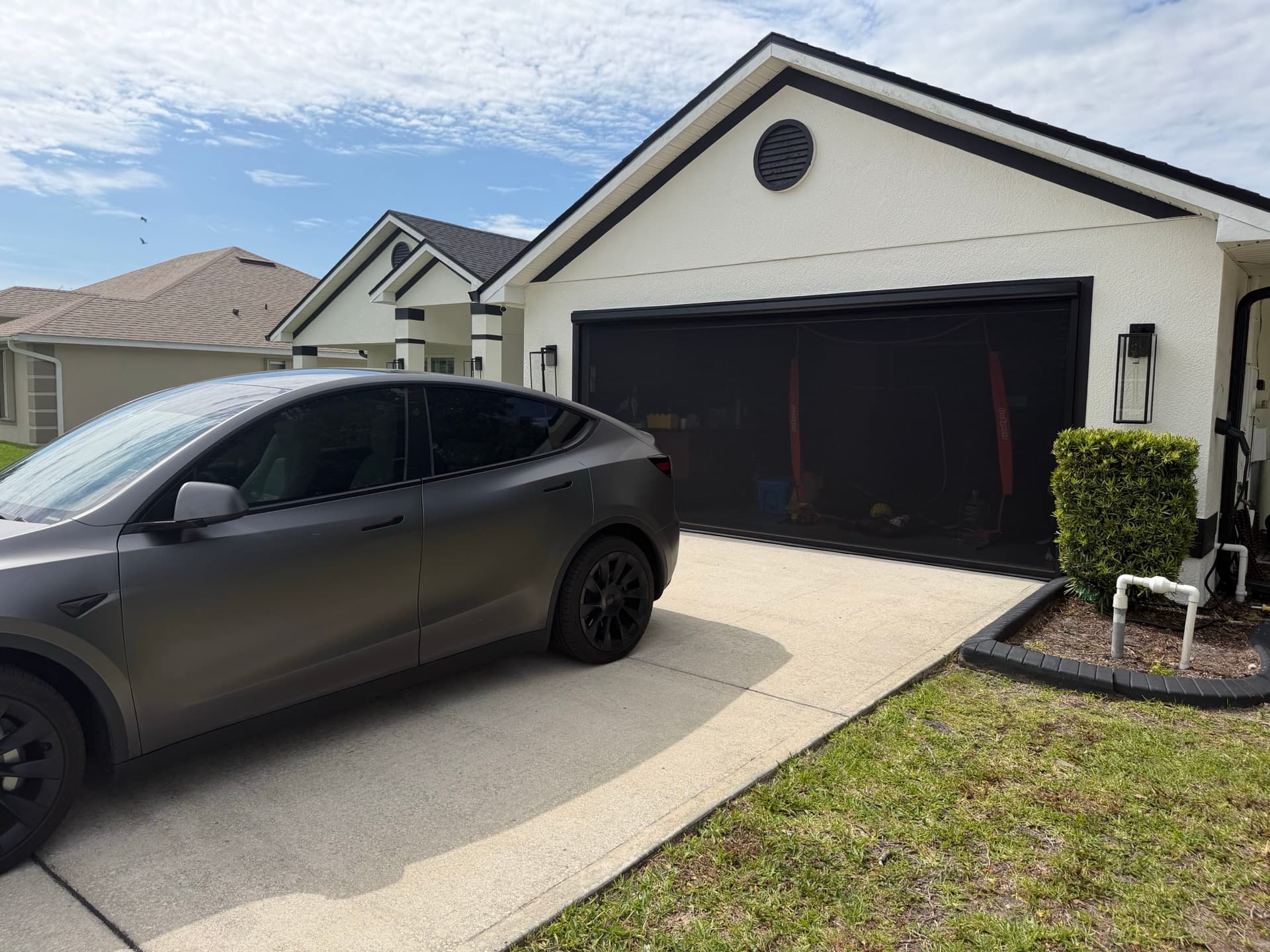 Black garage door screen installed across a two-car garage on a Florida home