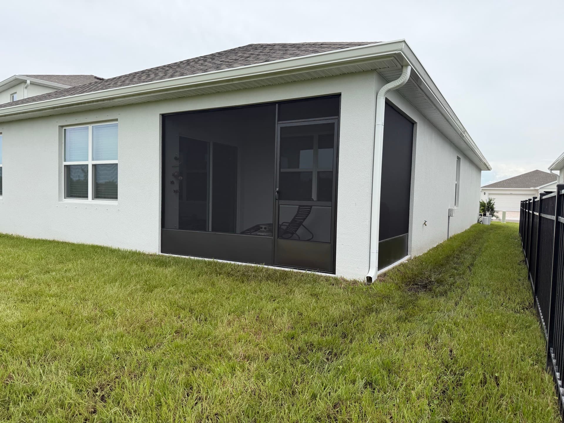 White seamless gutters and downspout on the rear corner of a Florida home