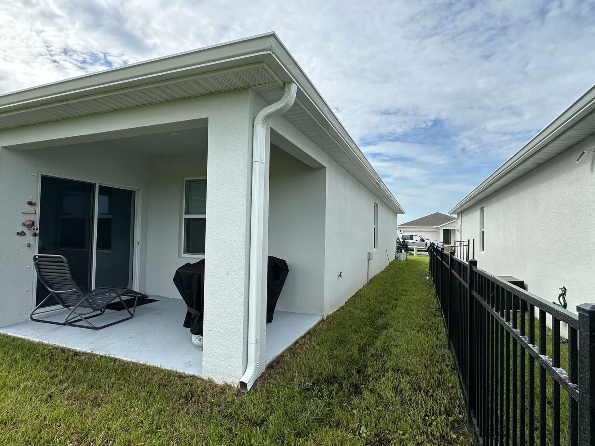 White seamless gutters and downspout wrapping the covered patio at the rear of a Florida home
