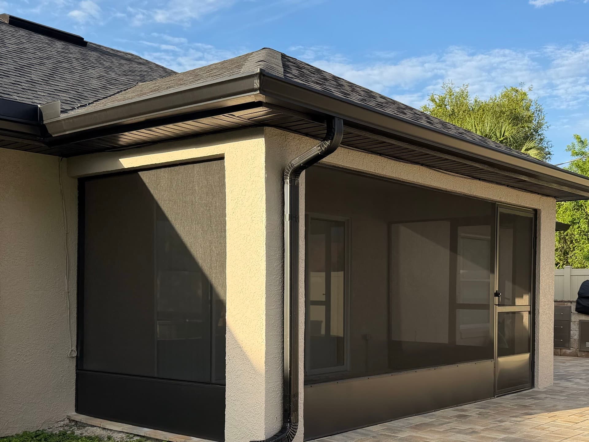 Seamless rain gutters and downspout installed on a Brevard County home with a screened patio